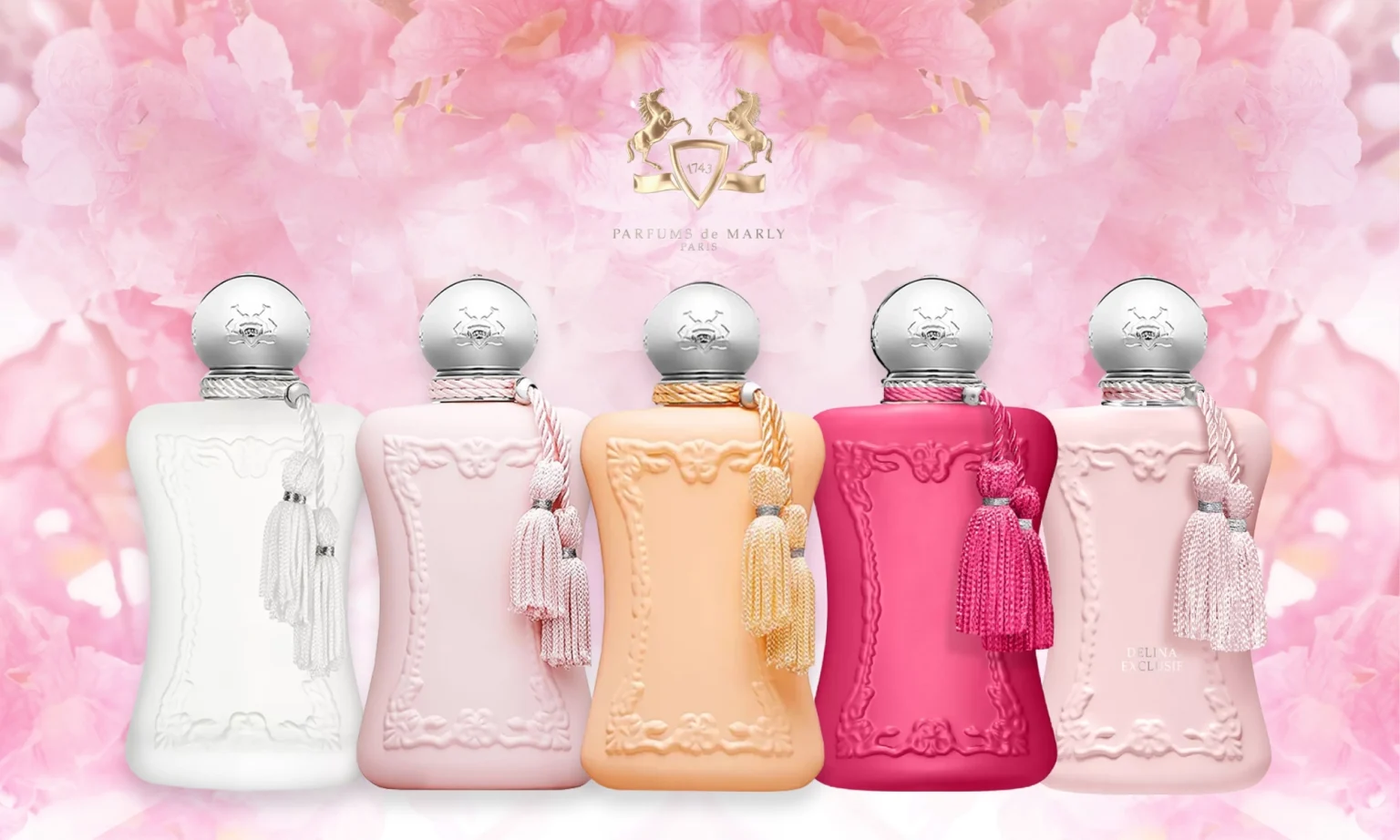 Parfums de Marly Delina fragrance collection featuring pastel pink, white, peach, and fuchsia bottles with tassels against a floral pink background